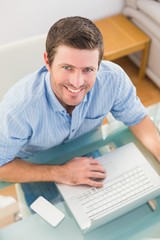 Smiling businessman using his laptop at desk