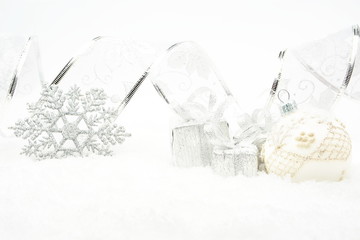 Fototapeta na wymiar Silver christmas baubles,gifts,snowflake with ribbon on snow