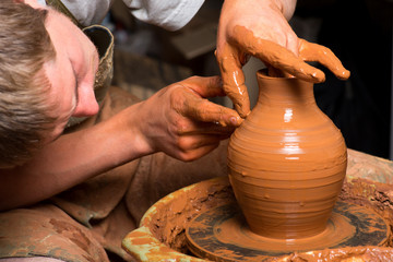 hands of a potter, creating an earthen jar