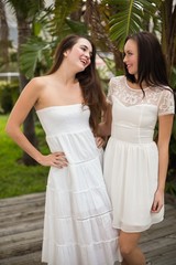 Fototapeta na wymiar Pretty friends smiling in white dresses