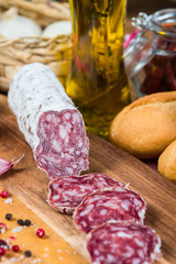 whole and sliced salami with garlic and oil with herbs