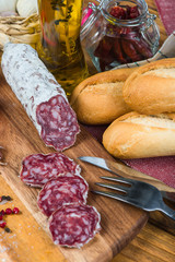 whole and sliced salami with garlic and oil with herbs