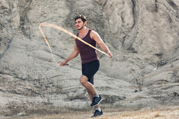 sporty man jumping rope outdoors