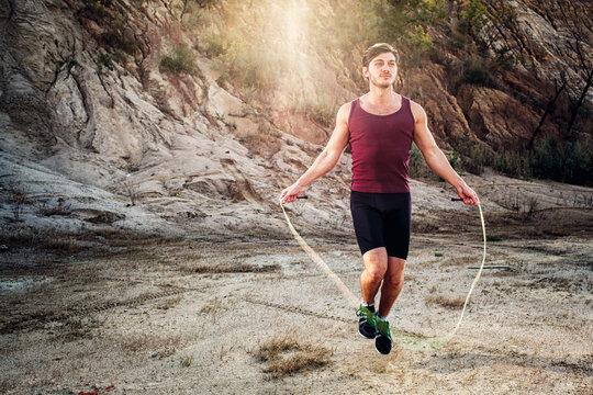sporty man jumping rope outdoors