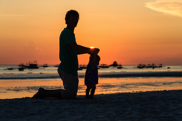 Silhouette of father and little daughter on sunset