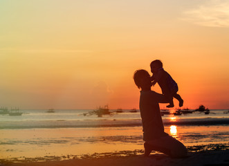 Fototapeta premium Father and little daughter silhouettes at sunset