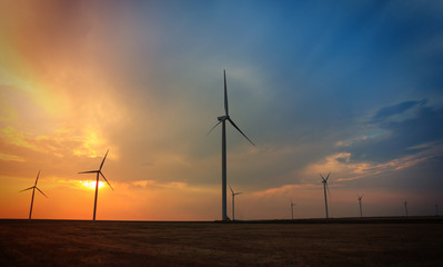 Rotating wind turbines at sunset