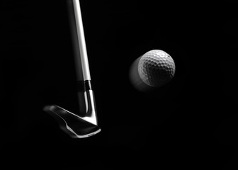 Swinging a golf iron/club with a golf ball in a mid air position - obrazy, fototapety, plakaty
