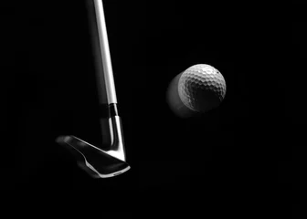 Papier Peint photo Golf Swinging a golf iron/club with a golf ball in a mid air position