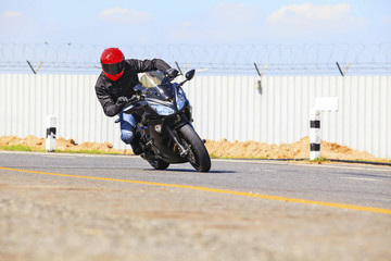 young man riding big bike motorcycle on sharp curve asphalt road