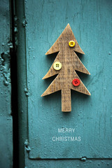 DIY wooden christmas tree with buttons on blue green pained wall