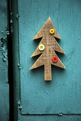 DIY wooden christmas tree with buttons on blue green pained wall