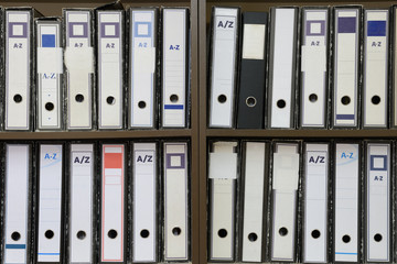 document folders stacked on a shelf