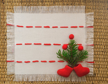 Christmas tree and red beads and boots on a linen napkin