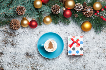 Cappuccino with christmas tree shape and gift box on artificial