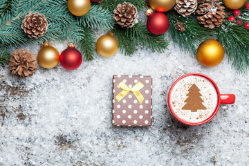 Cappuccino with christmas tree shape and gift box on artificial