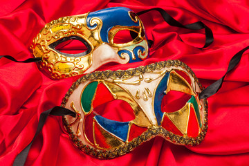 Two Mardi Gras Masks on red silk