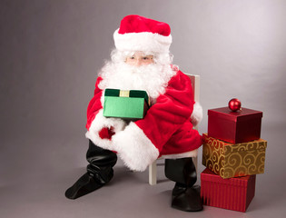 Little Girl Dressed as Santa Claus with a Stack of Christmas Presents