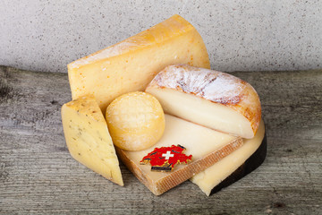 Head and various pieces of cheese on a wooden table.
