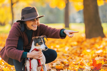 Happy young woman dog outdoors in autumn
