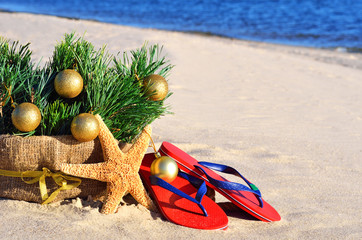 Christmas tree with christmas balls, slippers and starfish on th