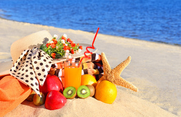 Fototapeta na wymiar Woman hat, different fruits, starfish and glass of juice on the