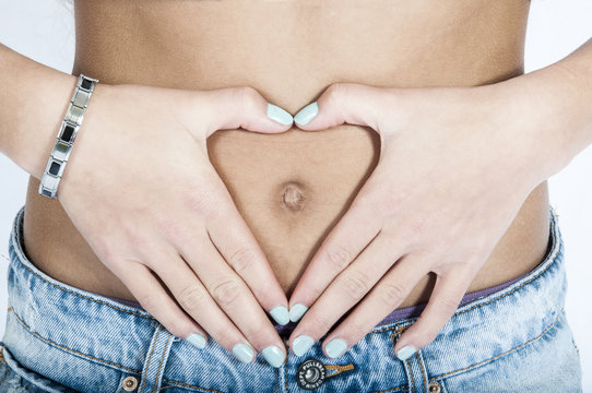 Mains en forme de coeur sur le nombril