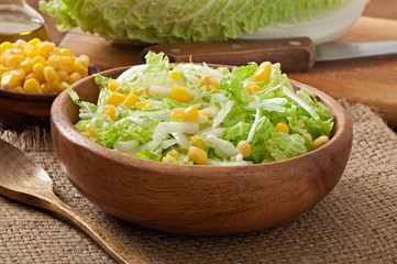 Chinese cabbage salad with sweet corn in a wooden bowl