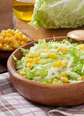 Chinese cabbage salad with sweet corn in a wooden bowl