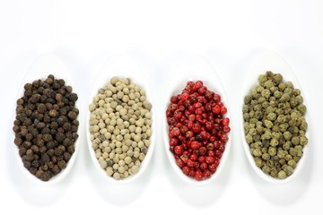 Pfefferkörner in Keramikschälchen isoliert auf weißem Hintergrund