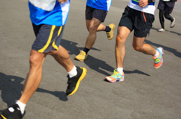 Fototapeta premium Unidentified marathon athletes legs running on street 