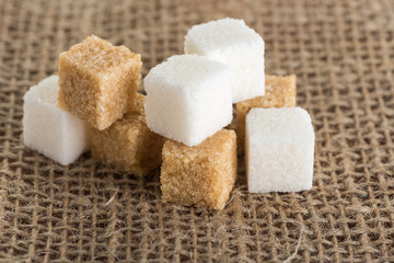 cubes of brown and white sugar on jute bags