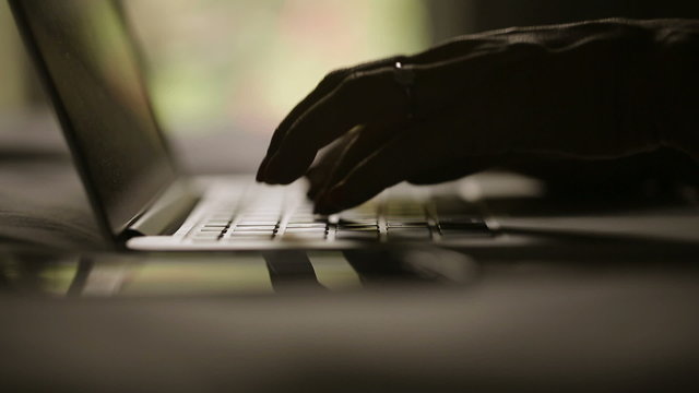 Fingers typing text on  keyboard.