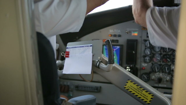 Cockpit inside. Hands pilots run gadgets of seaplane.