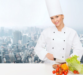 smiling female chef chopping vegetables