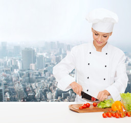 smiling female chef chopping vegetables