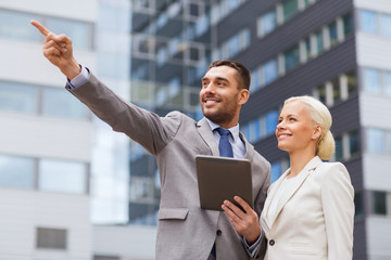 smiling businessmen with tablet pc outdoors