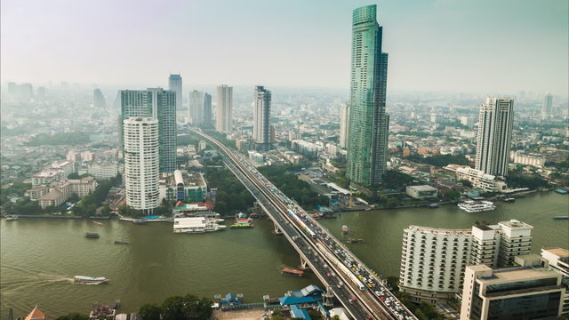 Timelapse hight view of Bangkok city with modern building,that cover with mist, and traffic at evening  along Chaopraya river
