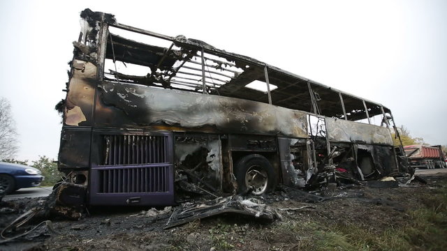 Burned-out passenger bus on the side of the road