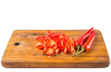 Slices of red chili peppers on wooden cutting board