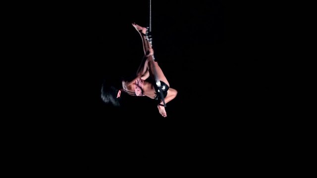 Young woman air gymnast on black background