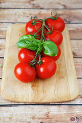 branch of red tomatoes on the board