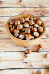 hazelnuts with shell in a wooden bowl