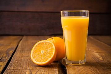 Fruit orange et verre de jus sur fond de bois marron
