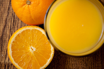 Orange fruit and glass of juice, top view