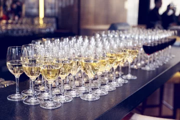 Fototapeten Glasses of white wine on bar counter, toned © Kondor83