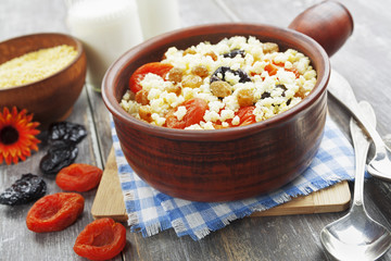 Millet porridge with dried apricots and prunes in a bowl