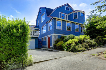 Fototapeta na wymiar Big house exterior in blue color with red trim