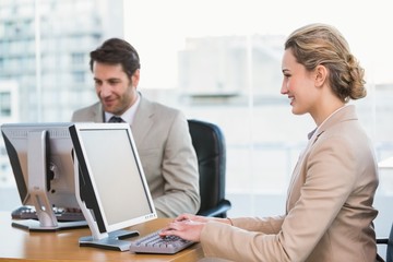 Smiling business people using computer