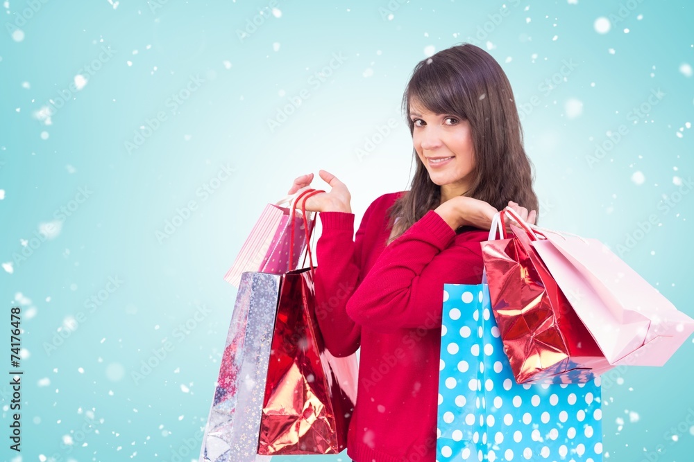 Wall mural composite image of smiling brunette holding shopping bags